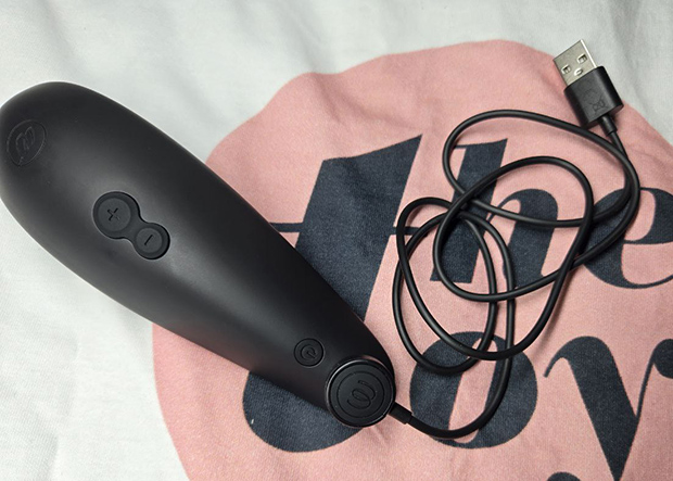 Womanizer Classic 2 connected to its USB magnetic charger, photographed during overnight charging. Highlights real-world issues with magnet alignment.