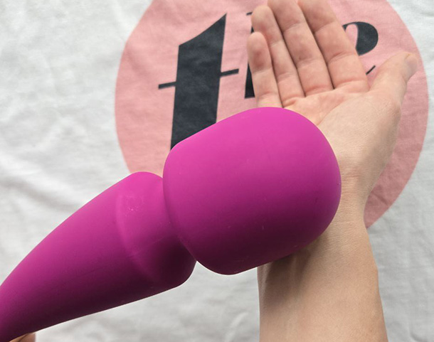 Close-up of the LELO Smart Wand 2 silicone head resting gently against a wrist, demonstrating its broad, rounded contact surface.