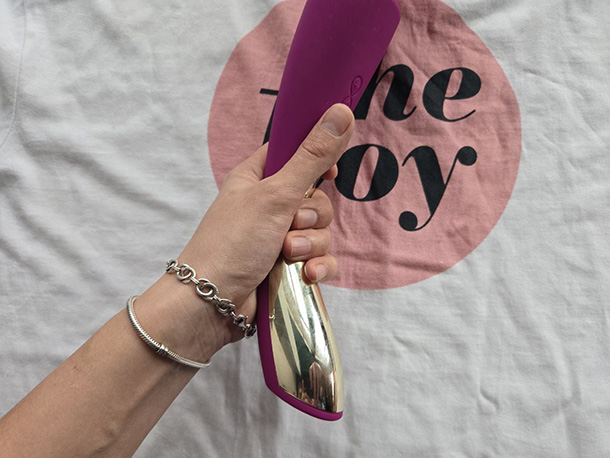 Two grip positions shown on the LELO Smart Wand 2 handle, illustrating that gripping at the curved center reduces hand vibration compared to holding at the base.