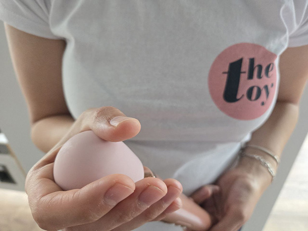 Amie showing Le Wand Petite head size compared to a small female hand.