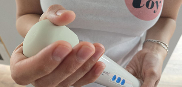 Close-up photograph of the Magic Wand Mini's white silicone head showing its cylindrical shape and smooth matte texture