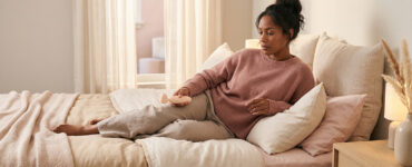 Woman reclining with subtle body tension in her jaw, abdomen, and legs during an intimate moment.