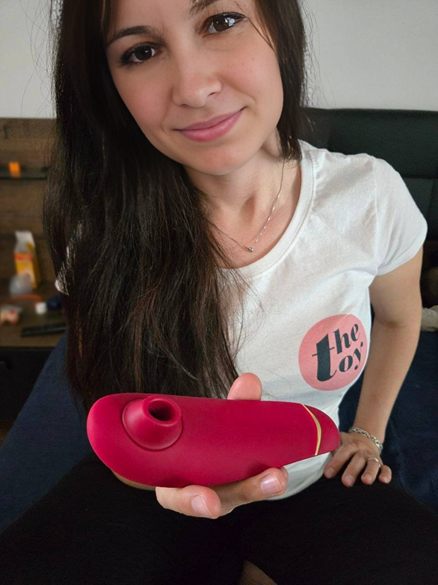 Amie Dawson holding Womanizer Premium in one hand with white TheToy t-shirt