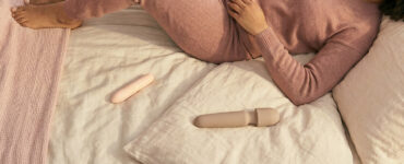photo of a person resting with a vibrator in warm light, suggesting subtle shifts in touch that change sensation from more pinpoint to more broad.