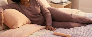 photo of a person alone on a bed in warm light with subtle signs of distraction nearby, suggesting how mental interruptions can pull someone out of pleasure