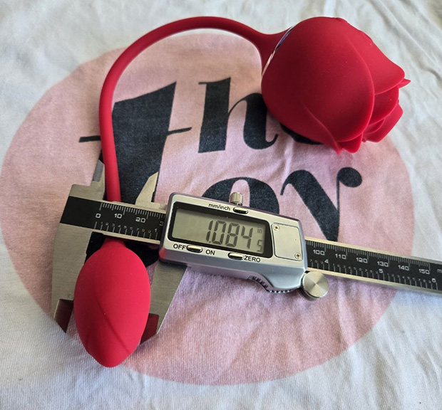 The compact egg vibrator portion of the Lovehoney Rose Glow measured with a digital caliper, showing its smooth silicone surface and the attached flexible silicone cord.