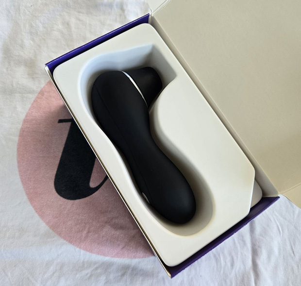 Lovehoney Thrill unboxing showing the black toy, a USB charging cable, and a small instruction booklet inside a simple cardboard box with no storage pouch included.