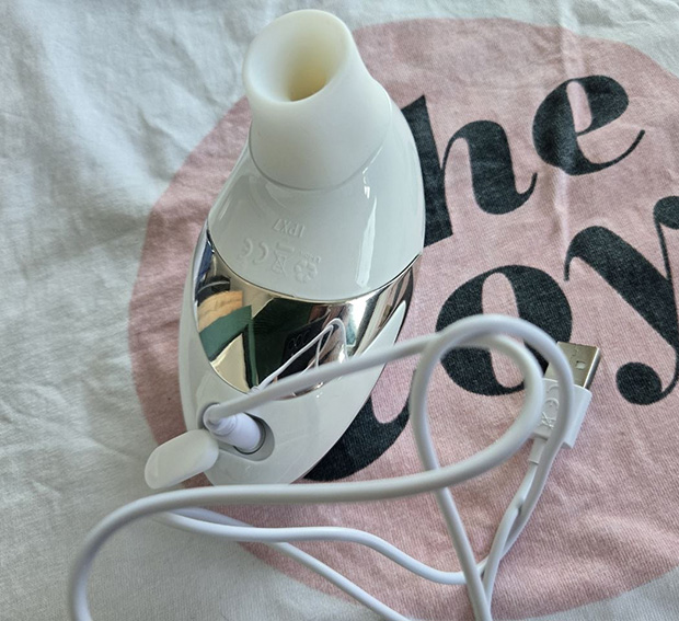 Top-down view into the Womanizer W500 small stimulation head showing the deep 1.18-inch chamber interior and its charging cable