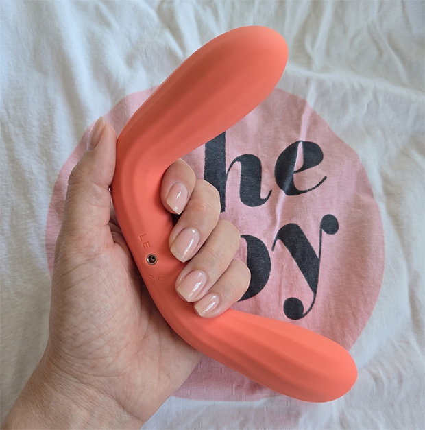 The LELO Boomerang vibrator being gently flexed at the middle section to demonstrate the flexibility of the shaft, while the insertable tip end remains rigid and maintains its curved shape in a female hand