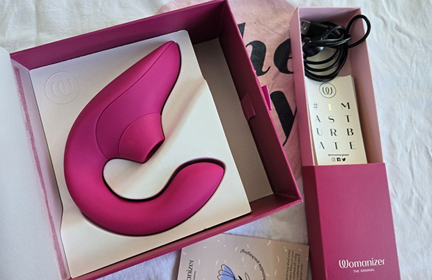 Womanizer Blend dual vibrator in Vibrant Rose color displayed with its magnetic charging cable and eco-friendly plant-fiber packaging.