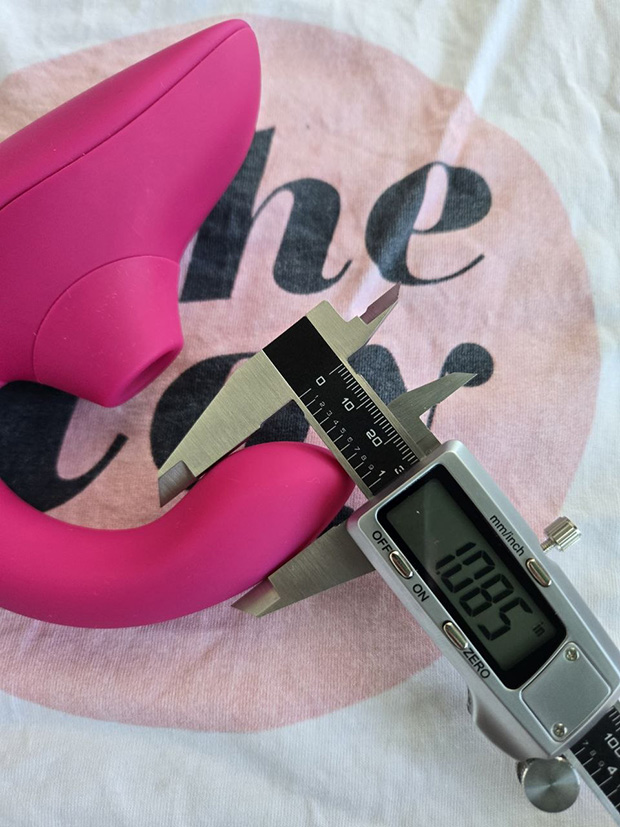 demonstrating the flexibility of the Womanizer Blend's curved silicone G-spot arm, showing moderate bend before it springs back